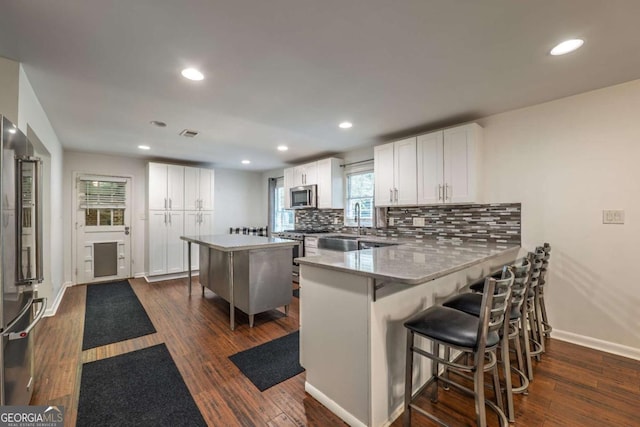 4240 Cascade Rd SW, Atlanta, GA 30331 - kitchen with dark wood-type flooring, white cabinetry, stainless steel appliances, and baseboards