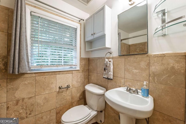 4240 Cascade Rd SW, Atlanta, GA 30331 - full bathroom featuring a shower, tile walls, toilet, and a sink