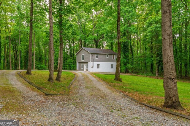 4240 Cascade Rd SW, Atlanta, GA 30331 - view of front facade with a front yard, gravel driveway, a view of trees, and an attached garage