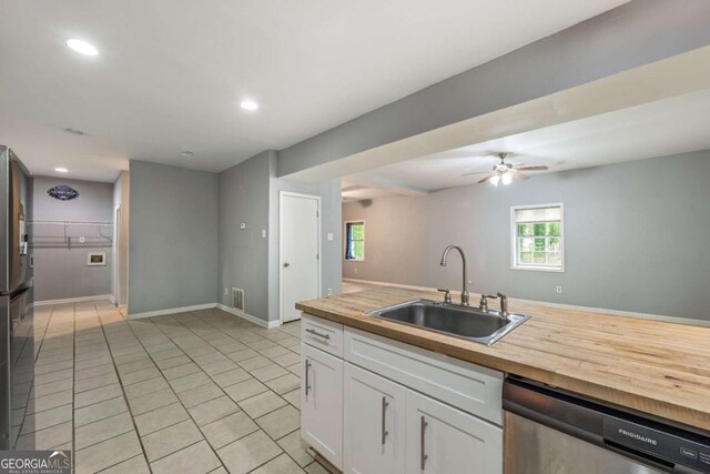 4240 Cascade Rd SW, Atlanta, GA 30331 - kitchen featuring stainless steel dishwasher, white cabinets, a sink, wooden counters, and light tile patterned flooring