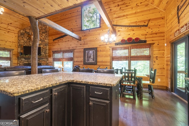 kitchen featuring wooden walls, an inviting chandelier, and open floor plan