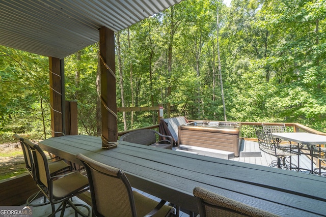 wooden terrace featuring a forest view and outdoor dining area