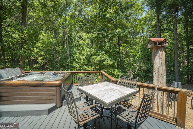 deck featuring outdoor dining space and a hot tub