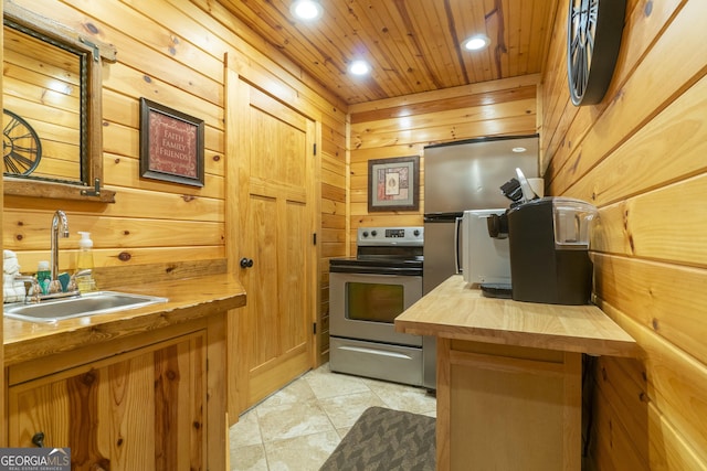 kitchen with wood counters, a sink, wood walls, electric range, and recessed lighting