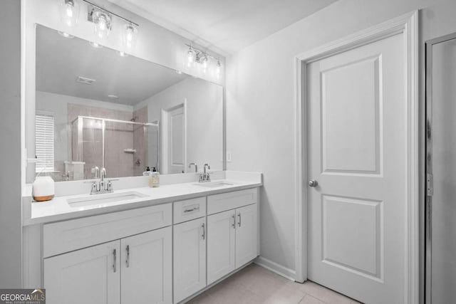 bathroom with double vanity, tile patterned floors, a shower stall, and a sink