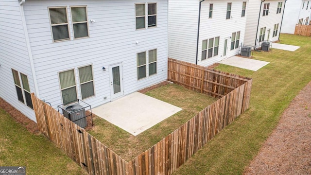 rear view of house featuring a fenced backyard, a patio, and a yard