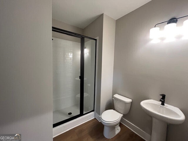 968 Bibbs Cir NW, Atlanta, GA 30318 - bathroom with baseboards, a stall shower, toilet, and wood finished floors