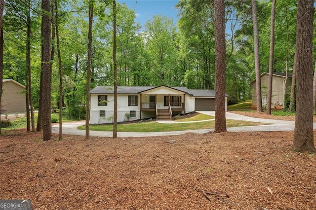 view of front of house with covered porch, concrete driveway, and a garage