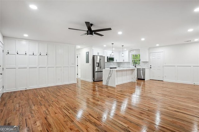 unfurnished living room with recessed lighting, a ceiling fan, and light wood finished floors