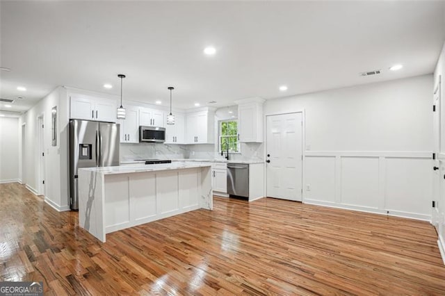kitchen with white cabinets, visible vents, stainless steel appliances, light countertops, and light wood-style floors
