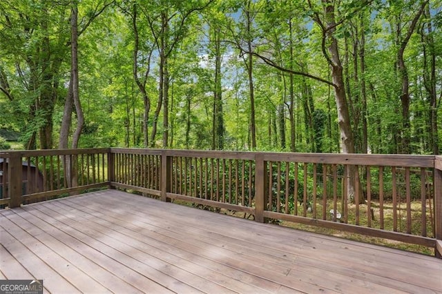 wooden terrace featuring a forest view