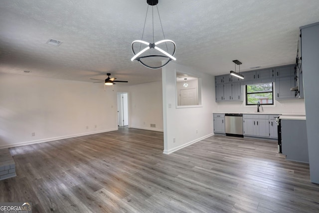 2931 Randolph Ct NE, Conyers, GA 30012 - unfurnished living room with a textured ceiling, ceiling fan with notable chandelier, baseboards, wood finished floors, and visible vents