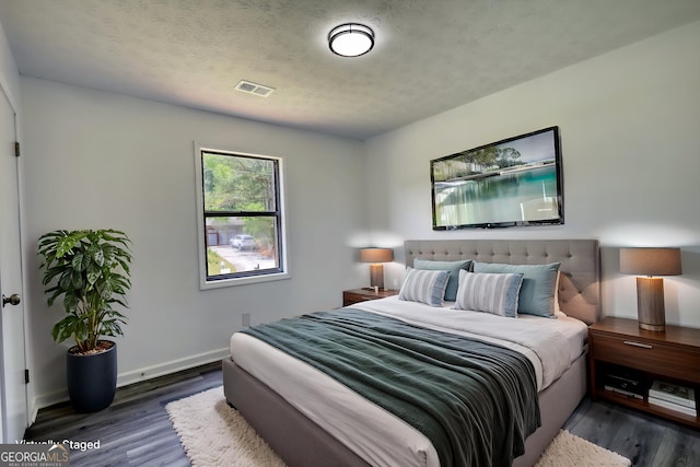 2931 Randolph Ct NE, Conyers, GA 30012 - bedroom featuring visible vents, a textured ceiling, baseboards, and wood finished floors