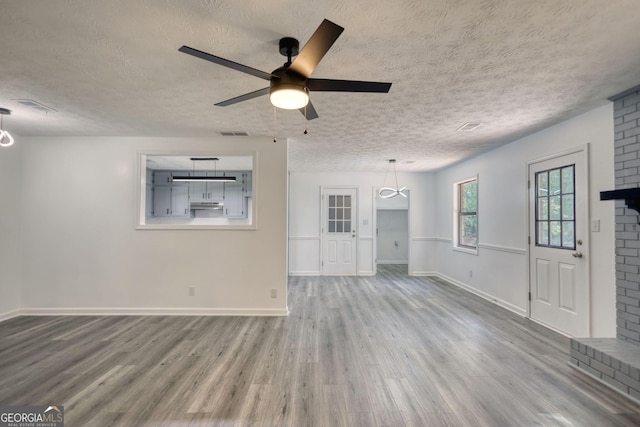 2931 Randolph Ct NE, Conyers, GA 30012 - unfurnished living room featuring a ceiling fan, a textured ceiling, and wood finished floors