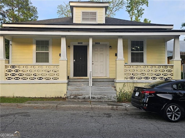 view of front of house featuring roof with shingles and covered porch