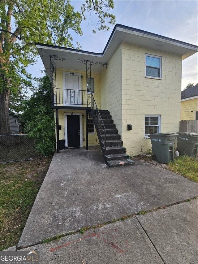 view of front of property featuring stairway and fence