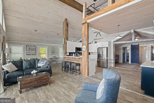 43 Cowan Ct, Mansfield, GA 30055 - living area featuring high vaulted ceiling, a barn door, light wood finished floors, and wooden ceiling