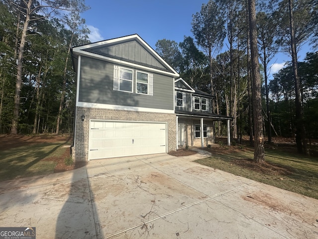 view of front of house with an attached garage, concrete driveway, a porch, and brick siding