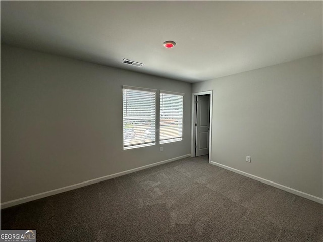 empty room featuring carpet flooring, baseboards, and visible vents