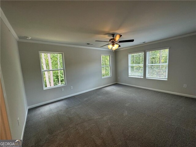 empty room featuring baseboards, ornamental molding, dark carpet, and visible vents