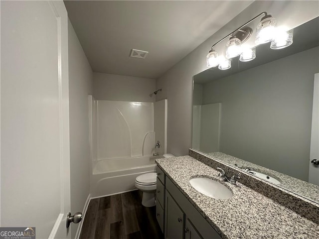 full bathroom with visible vents, wood finished floors, vanity, toilet, and tub / shower combination
