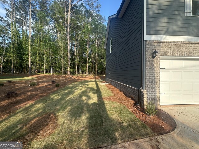 view of property exterior featuring a garage, a yard, and brick siding