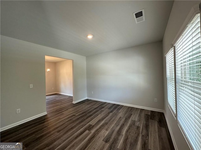 spare room featuring visible vents, recessed lighting, dark wood-style flooring, and baseboards