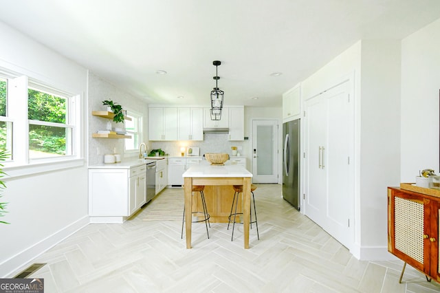 kitchen featuring baseboards, light countertops, white cabinetry, and appliances with stainless steel finishes