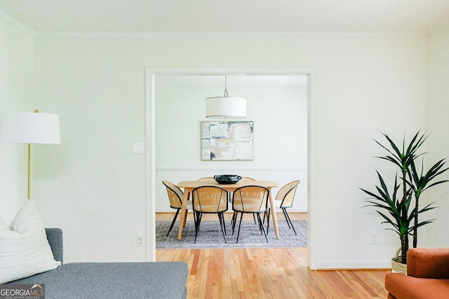 dining room featuring light wood-type flooring, baseboards, and crown molding