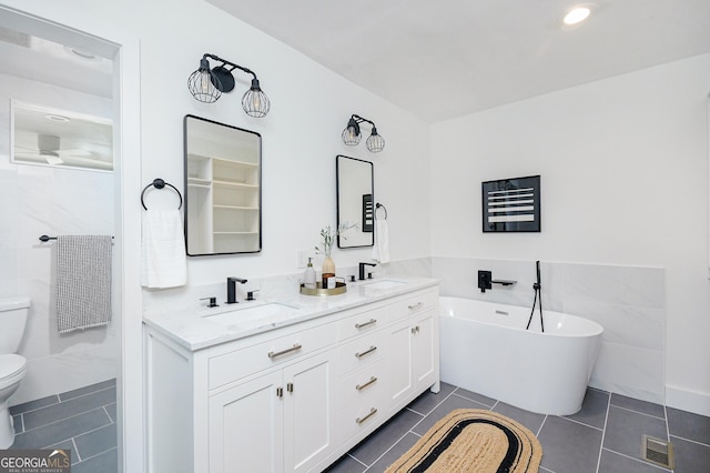 1662 Rainier Falls Dr NE, Atlanta, GA 30329 - full bathroom featuring tile patterned floors, toilet, a soaking tub, double vanity, and tile walls