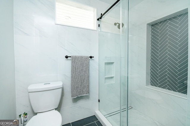 full bath featuring a stall shower, toilet, and tile walls