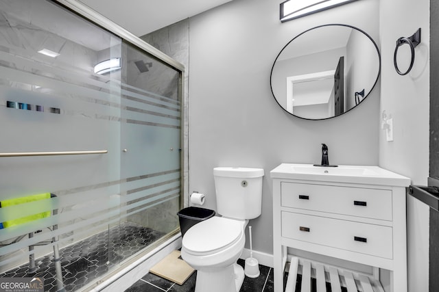 bathroom with vanity, baseboards, a stall shower, and toilet