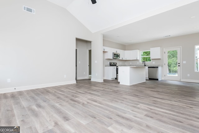 516 Branch St, Cedartown, GA 30125 - unfurnished living room with light wood-type flooring, a ceiling fan, visible vents, vaulted ceiling, and baseboards