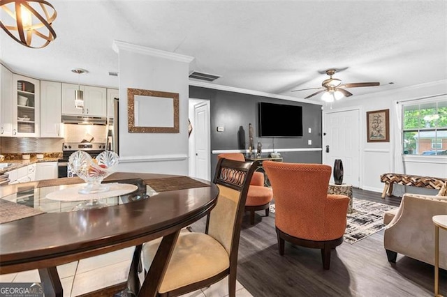 dining area with visible vents, wood finished floors, a ceiling fan, and ornamental molding