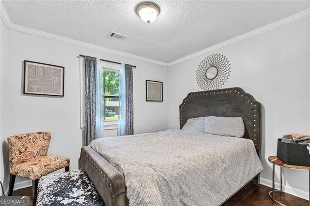 bedroom featuring a textured ceiling, visible vents, baseboards, ornamental molding, and dark wood-type flooring