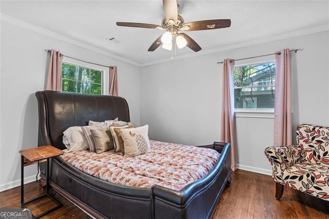 bedroom featuring ornamental molding, dark wood-style flooring, and multiple windows