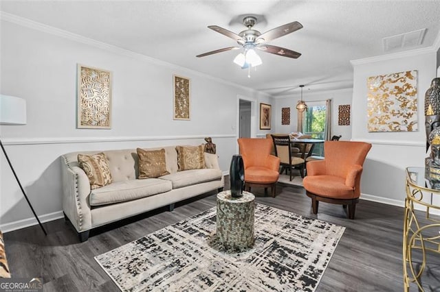 living room with crown molding, visible vents, baseboards, wood finished floors, and a ceiling fan