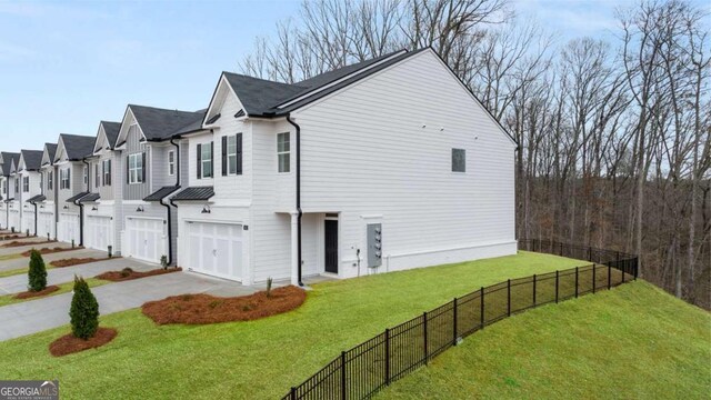 322 Sound Cir Unit 118, Stockbridge, GA 30281 - view of property exterior with a residential view, a yard, driveway, an attached garage, and fence