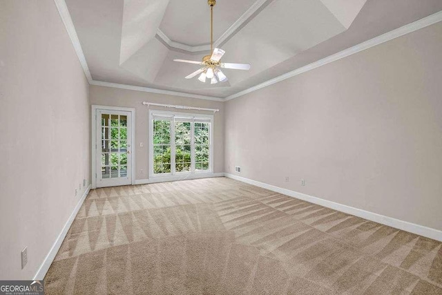 carpeted spare room with crown molding, a ceiling fan, a raised ceiling, and baseboards