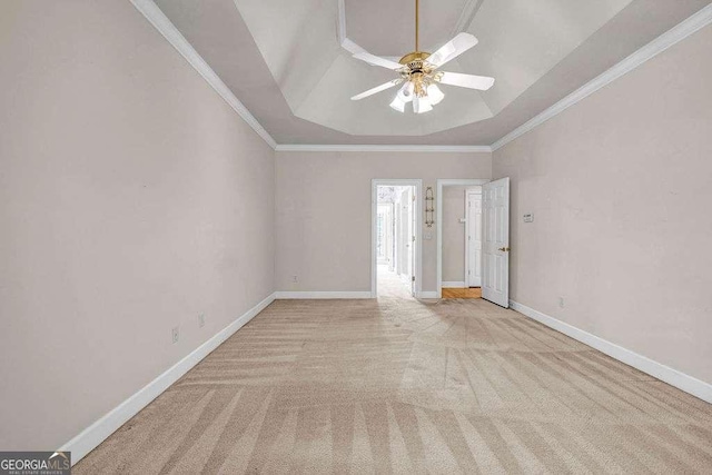 unfurnished room with carpet flooring, a tray ceiling, baseboards, ornamental molding, and a ceiling fan