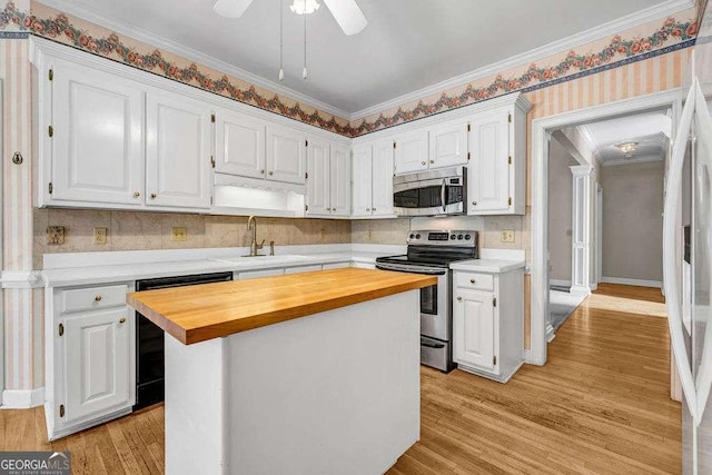 kitchen featuring white cabinetry, butcher block countertops, appliances with stainless steel finishes, and a sink
