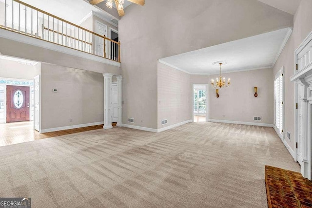 unfurnished living room featuring light colored carpet, a towering ceiling, visible vents, and baseboards
