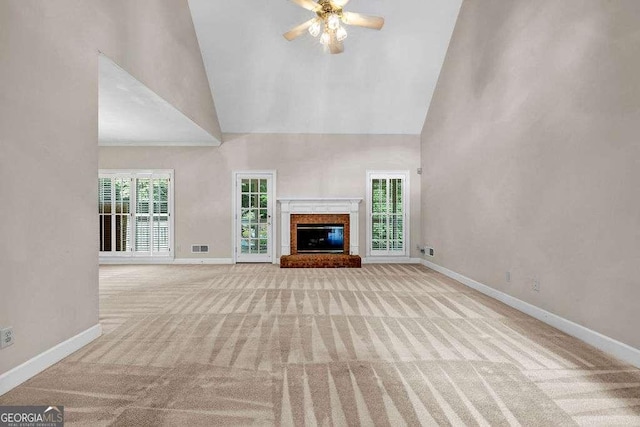unfurnished living room featuring a fireplace, high vaulted ceiling, carpet floors, and baseboards