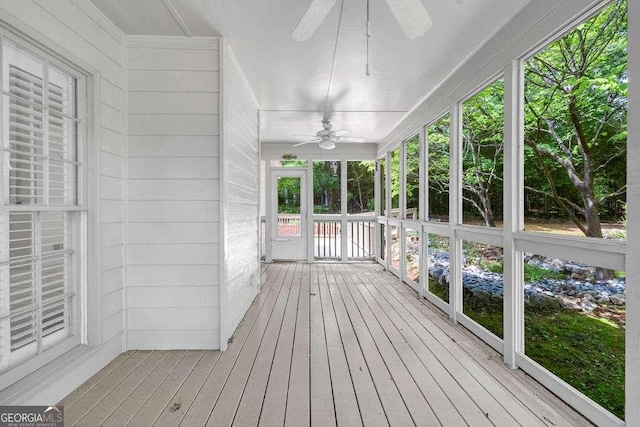unfurnished sunroom featuring ceiling fan