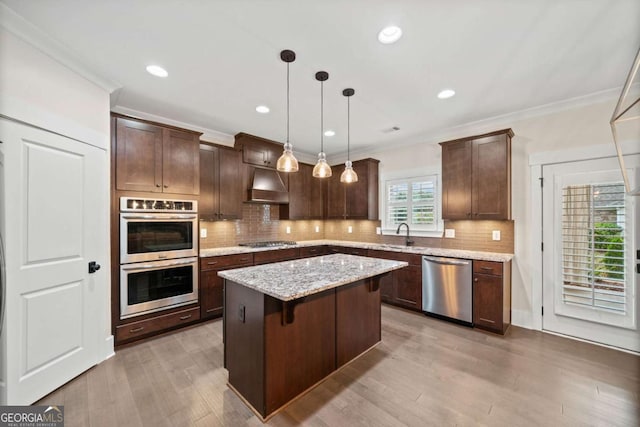 kitchen featuring dark brown cabinets, stainless steel appliances, extractor fan, and a center island
