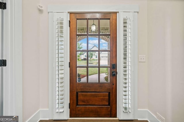 doorway featuring baseboards