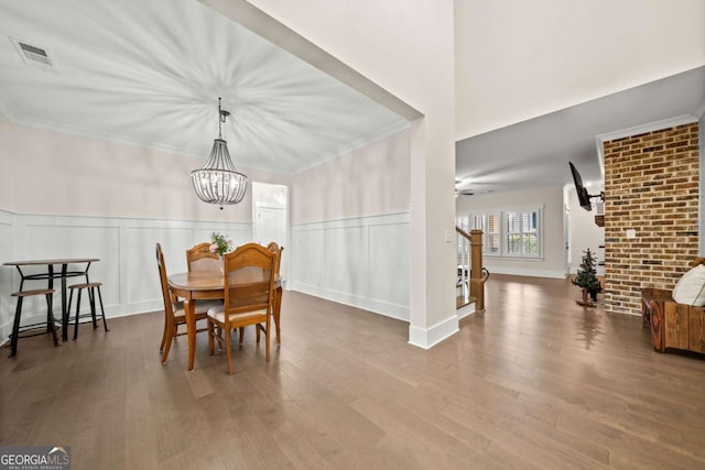 dining area featuring an inviting chandelier, wood finished floors, and visible vents