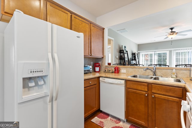 145 Begonia Ct, Griffin, GA 30223 - kitchen featuring white appliances, a sink, brown cabinets, a ceiling fan, and tasteful backsplash