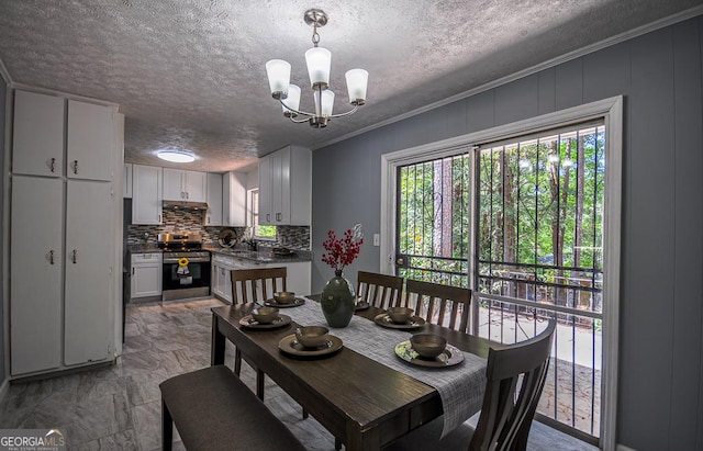 dining area featuring a textured ceiling, crown molding, and a notable chandelier
