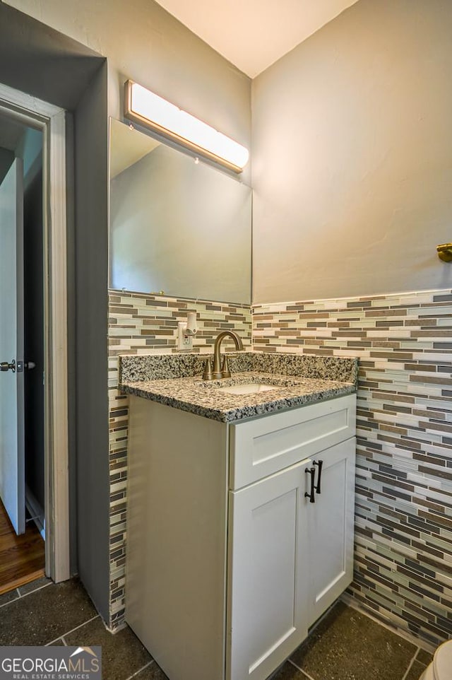 bathroom with tasteful backsplash, vanity, and tile walls